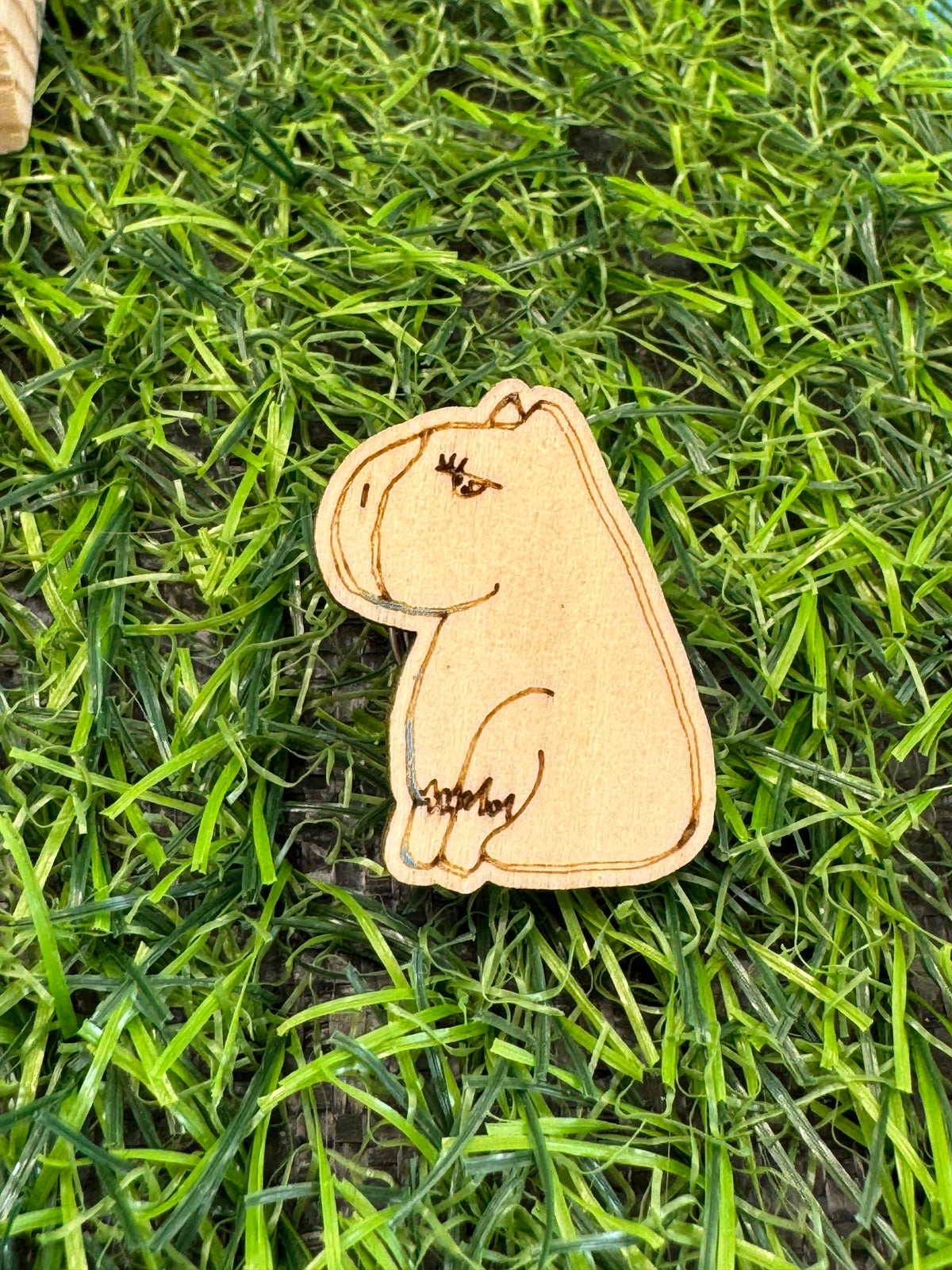 An image of a hand drawn wooden capybara pin badge